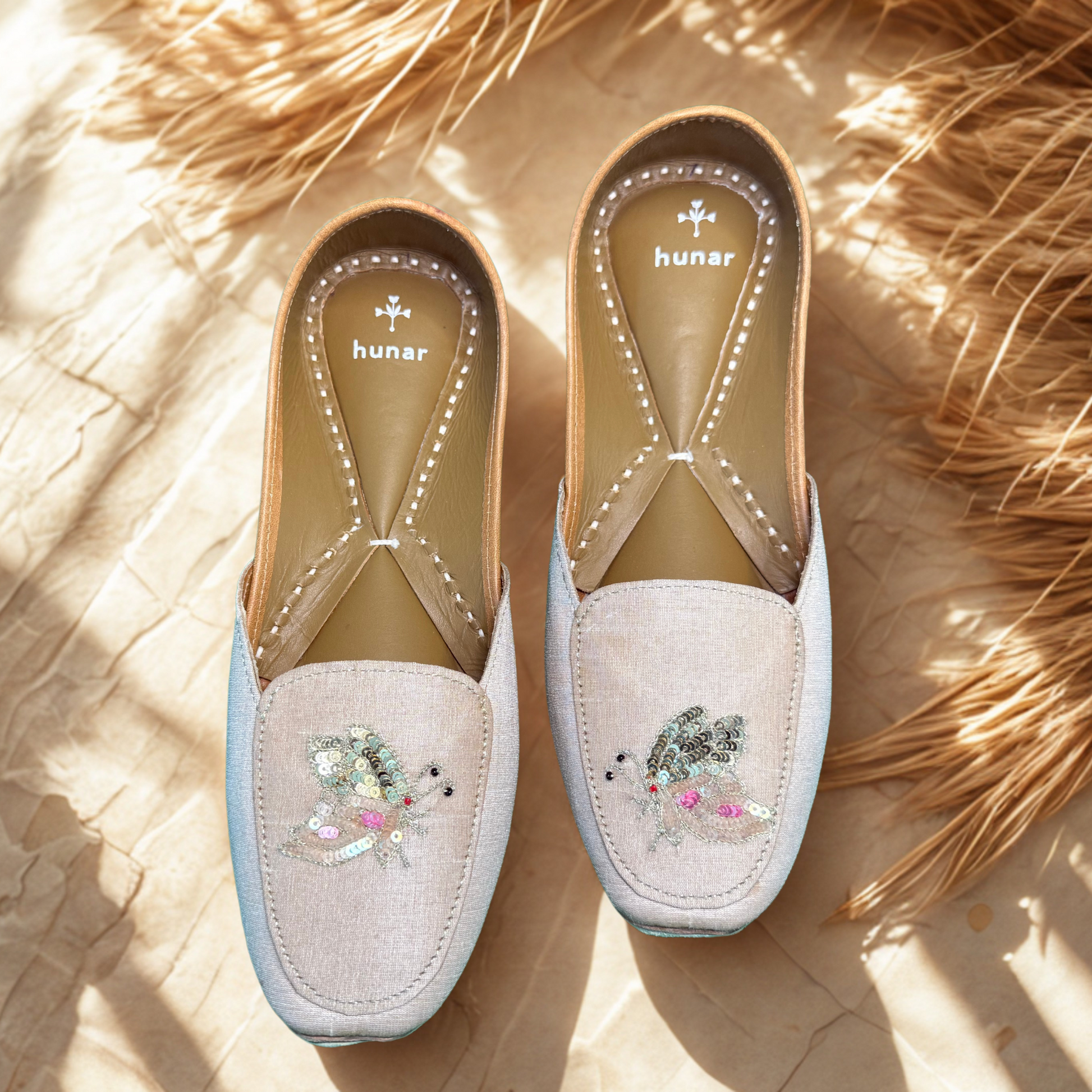 Pair of embroidered, handmade shoes on a textured surface